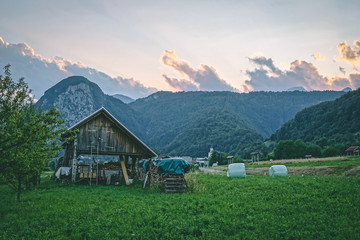 Fototapeta na wymiar Wooden cottage in Slovenian Alps landscape at sunset