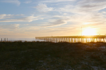 Fototapeta na wymiar Panama city beach florida pier at sun down with beach silhouette and multi colored sky