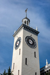 Russia, Black Sea, Sochi: Clock tower of famous central railway station main building (Vokzal) in the city center of the Russian town with blue sky - concept transport travel traffic destination