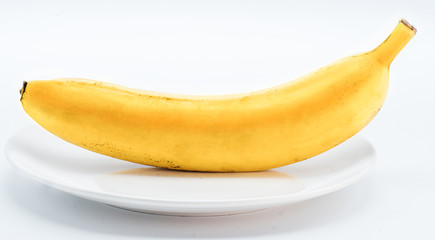 One fresh  yellow banana on the white plate isolated on white background.