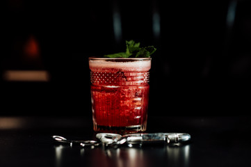 cocktail in a dark key, on a dark background, with different metal details
