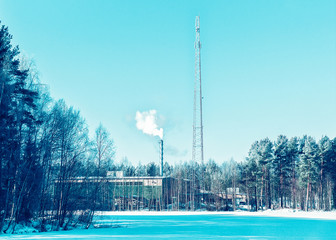 Factory chimney and steam in winter countryside at Finland