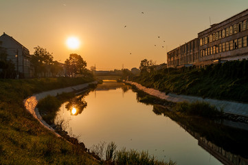 Fototapeta premium A view of the Bega river early in the morning. Sunrise in the city. The leather and glove factory.
