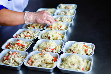 Food delivery. preparing food portions in containers. delivery service during quarantine covid-19. Chicken with vegetables and cheese. airline food. airline meals and snacks. takeaway selective focus