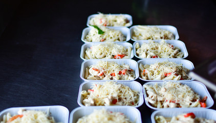 Food delivery. preparing food portions in containers. delivery service during quarantine covid-19. Chicken with vegetables and cheese. airline food. airline meals and snacks. takeaway selective focus