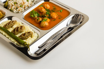 Traditional Turkish meals,meatballs soup,rice,mashed potatoes,grilled meatball and two slices of baklava in stainless steel food tray.Table d'hote(known Tabldot in Turkey) top view.