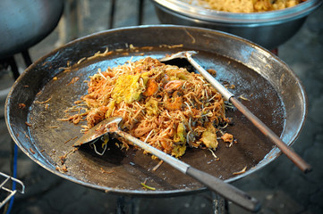 Seafood paella preparation in Thai street restaurant.