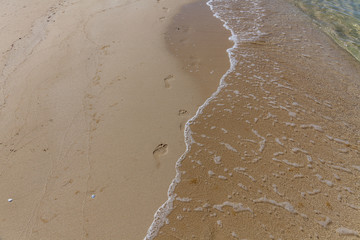 human footprints in the sand on the ocean. Sand Texture. Background from brown sand.