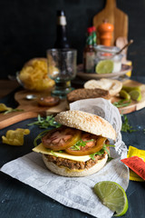Delicious quorn hamburger with vegan cheese, lettuce, some tomato slices and mustard between two sesame bread pieces