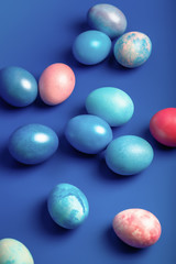 Easter still life with blue and pink dyed eggs on a blue background. 