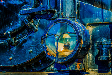 Headlight of a vintage steam locomotive of a pre-electricity age. Household oil lamp is used inside the headlight. History of the railroad transport.