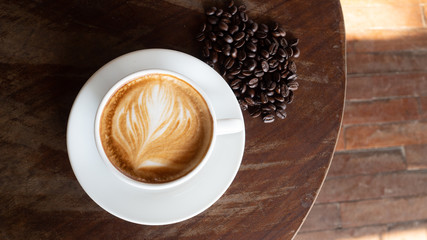 Black coffee bean, white round shape coffee cup on old wooden table top view. lifestyle concept