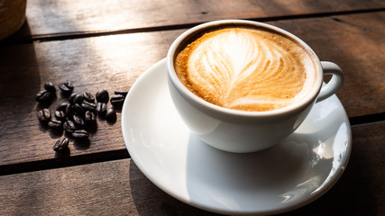 Black coffee bean, white round shape coffee cup on old wooden table top view. lifestyle concept