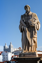 Obraz premium Saint Vincent, statue in Miraduro de Santa Luzia, famous viewpoint of Lisbon, Portugal, with che church of Sao Vincente de Fora on background