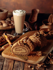Walnut cake and coffee latte with cream on a wooden table.