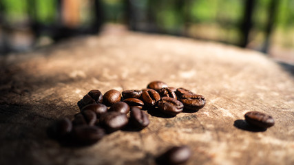 Obraz premium coffee beans on wooden table with sun light. coffee lover lifestyle concept