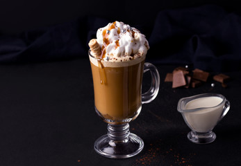 sweet coffee with caramel and cream on a black background. copy space