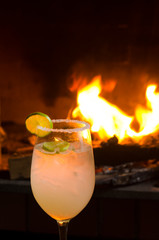 glass of margarita cocktail with fire and black background