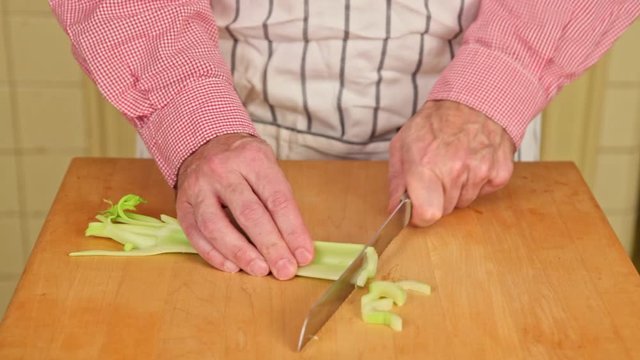 Man slices celery with knife.