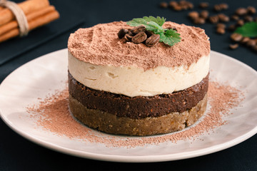  Tiramisu on a beige plate. Coffee with cinnamon. Raw dessert