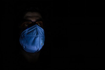 Male introvert character in white mask self-isolating in his dark apartment. Quarantine spooky...