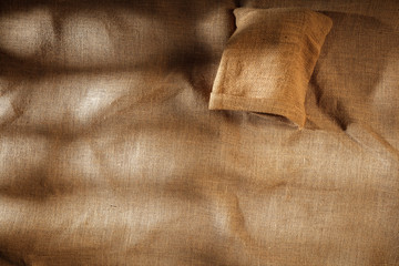 Flat light brown beige linen background seen from above with copy space for advertising products.