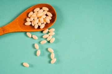 Wooden spoon with a measuring tape on a blue background, diet, healthy lifestyle.