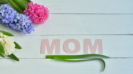 MOM word made with flower petals and leaves. Mother's day creative concept background. Colorful hyacinths
