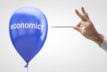 Concept: Threat to economic stability. Blue balloon and needle in hand.