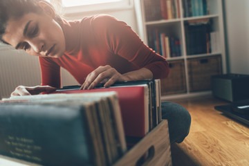 Young woman searching her favorite vinyl record