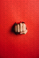 Human hand tearing red paper with the word coronavirus, concept in the fight against coronavirus