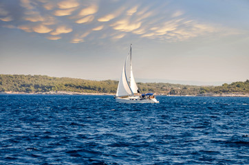 Obraz premium sailboat at sea under a magnificent sunset