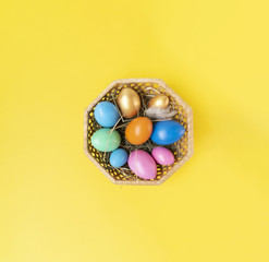 Colorful eggs on the bright yellow background. Copy space. Place for text and design. Happy Easter!