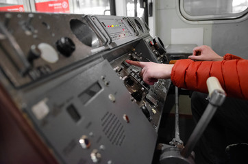 subway train cabin and dashboard. Hand of subway driver on the lever of the train. cabin train from the inside, railway devices for controlling the train