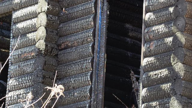 burnt wooden log house, charred wood