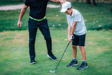 Golf &ndash; Personal Training. Golf Instructor Teaching Young Boy How to Play Golf.