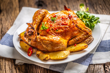 Roasted chicken and american potatoes with chili peppers and herbs