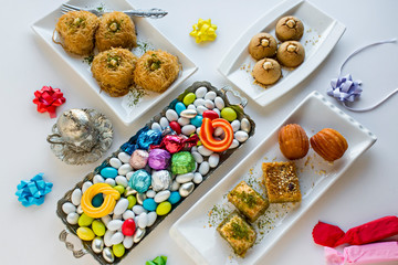 Setting stylish table with traditional pastry desserts and colorful candies for Sugar Feast end of Ramadan.Taken from above.