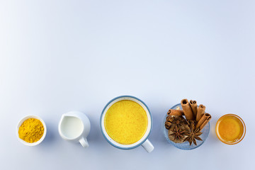 Golden milk, turmeric, honey, ginger root, cinnamon and other ingredients on grey background. Masala Haldi Doodh