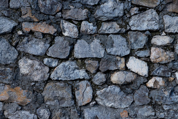 Texture of stone wall made of grey stones