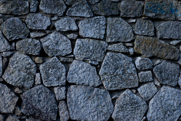 Texture of stone wall made of grey stones
