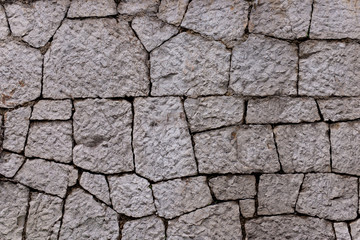 Texture of stone wall made of grey stones