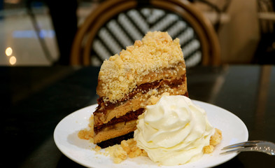 Slice of Banoffee Pie Cake with Fluffy Whipped Cream on a White Plate
