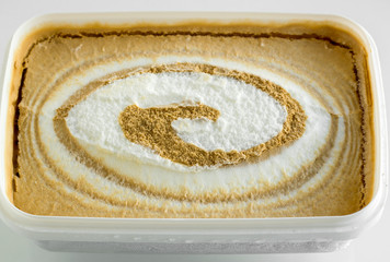 Vanilla and caramel ice cream in white plastic cup,close-up taken.