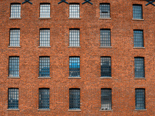 Fototapeta na wymiar Facade / front of an old factory building made of red brick with a lot of vintage windows