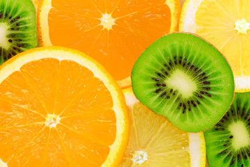 Full frame tropical fruit background - slices of kiwi, orange and lemon in close-up 