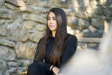 Portrait of a young woman sitting on an urban stone staircase