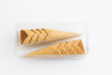 Crispy,Conical Eight Cones of Ice Cream in the transparent,plastic own box on the white surface.