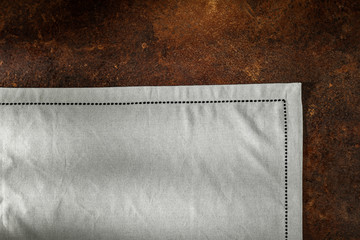 Flat dark brown background with grey tablecloth seen from above with copy space for advertising...