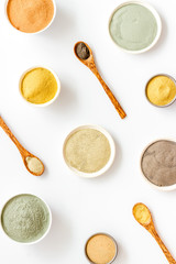 Blue, yellow, white. red, black cosmetic clay background on white table top-down